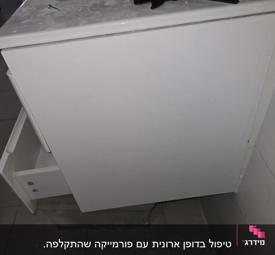 ארון אמבטיה עם מגירה פתוחה וכלי עבודה על השיש